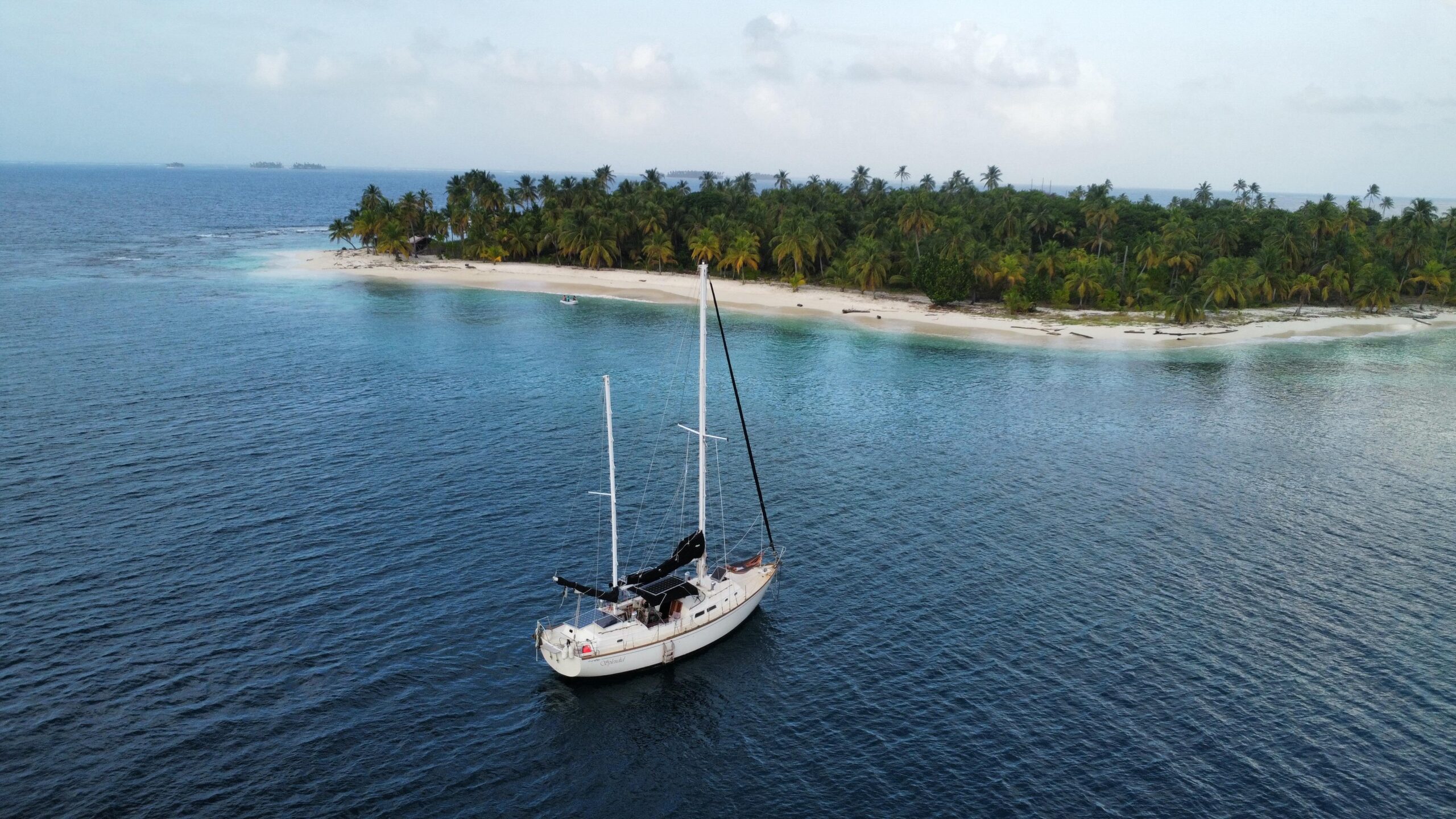 Choy Lee 39 classic sail yacht anchored offshore in San Blas, near a lush tropical island